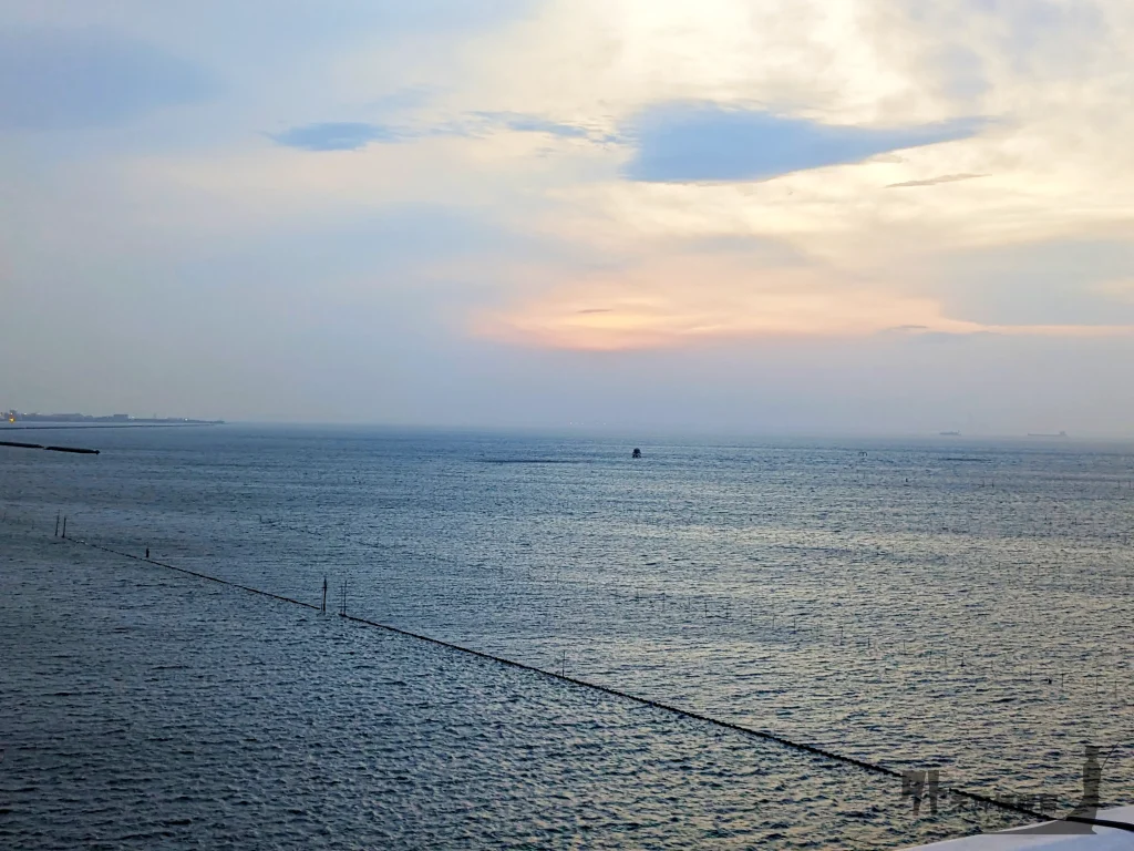 朝日が昇り徐々に空が明るくなってくる様子。海面がキラキラ。